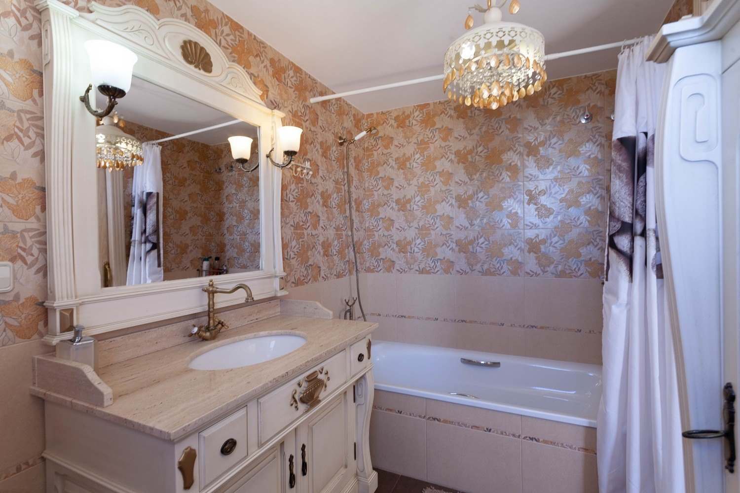 Klassieke badkamer met marmeren wastafel, sierlijke spiegel en bad met douche.