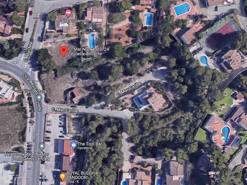 Satellietluchtfoto die de exacte locatie van het perceel in Moraira toont, omgeven door gevestigde woonwijken met directe toegang vanaf de straat Mar Caribe.