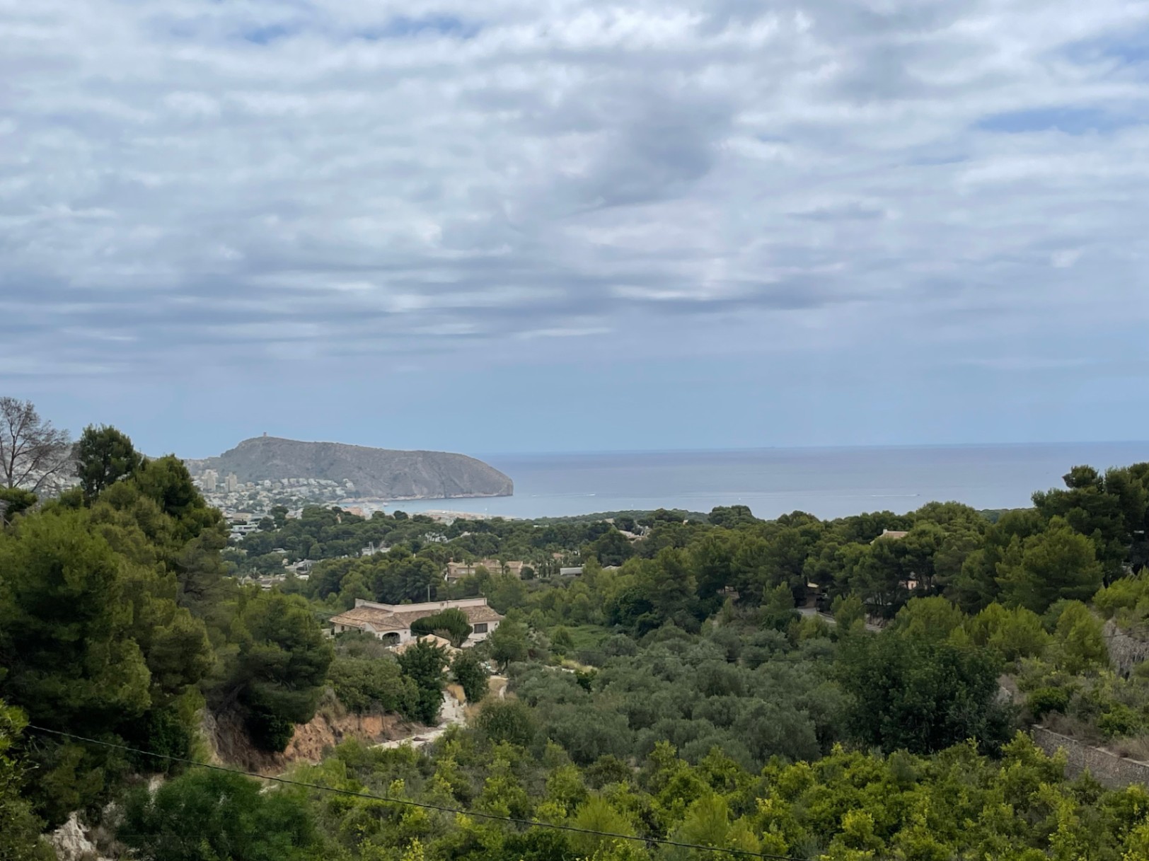Panoramisch uitzicht vanaf de bouwkavel in Benimeit over de groene vallei naar de Middellandse Zee en de kenmerkende Cap d'Or van Moraira.