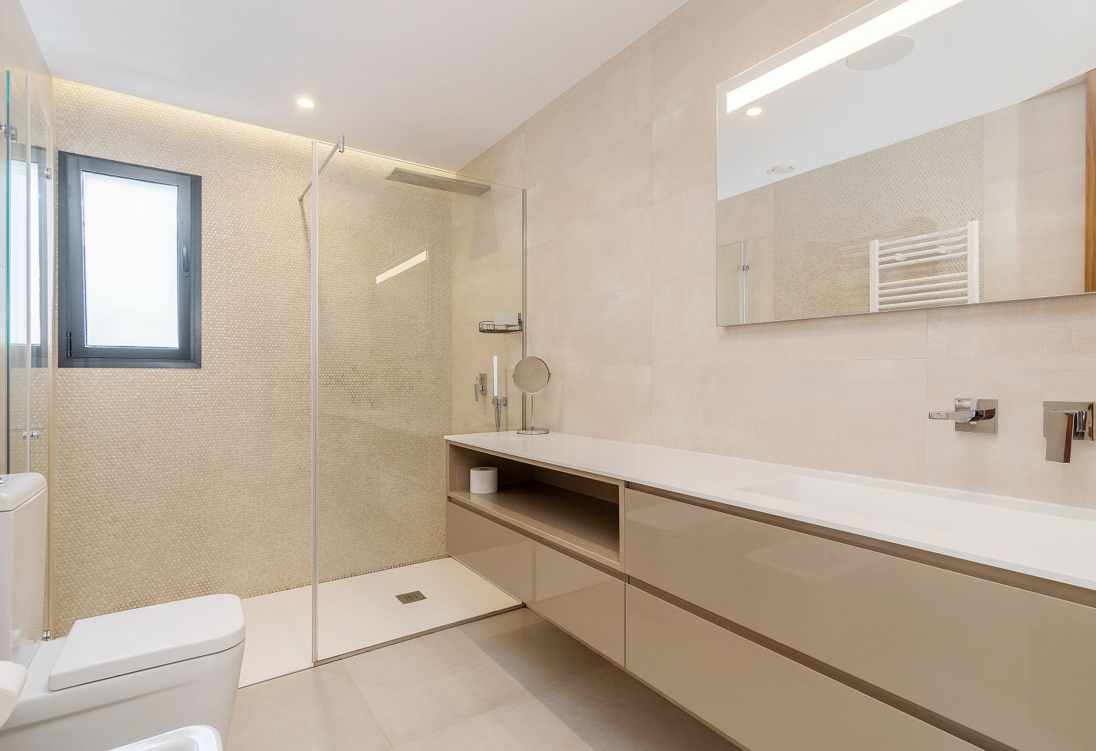 Moderne badkamer met inloopdouche, glazen wand, zwevend wastafelmeubel en beige wandtegels gecombineerd met een verfijnde mozaïekwand.