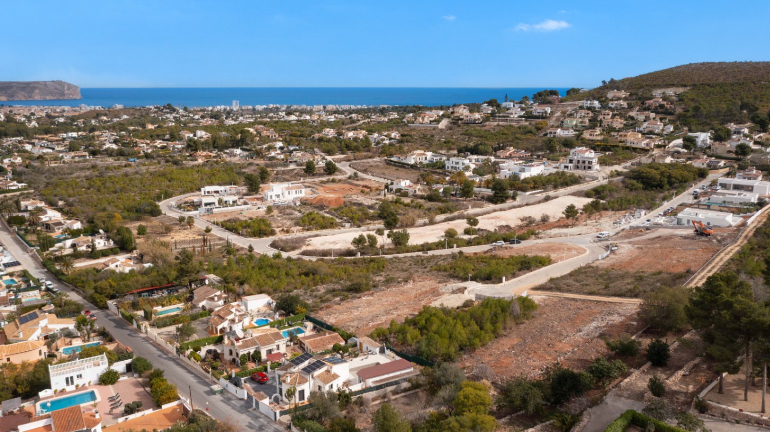 Luchtfoto van de woonwijk Lomas Del Rey in Jávea, met bouwpercelen die een panoramisch uitzicht bieden op de Middellandse Zee en de omliggende dennenbossen.