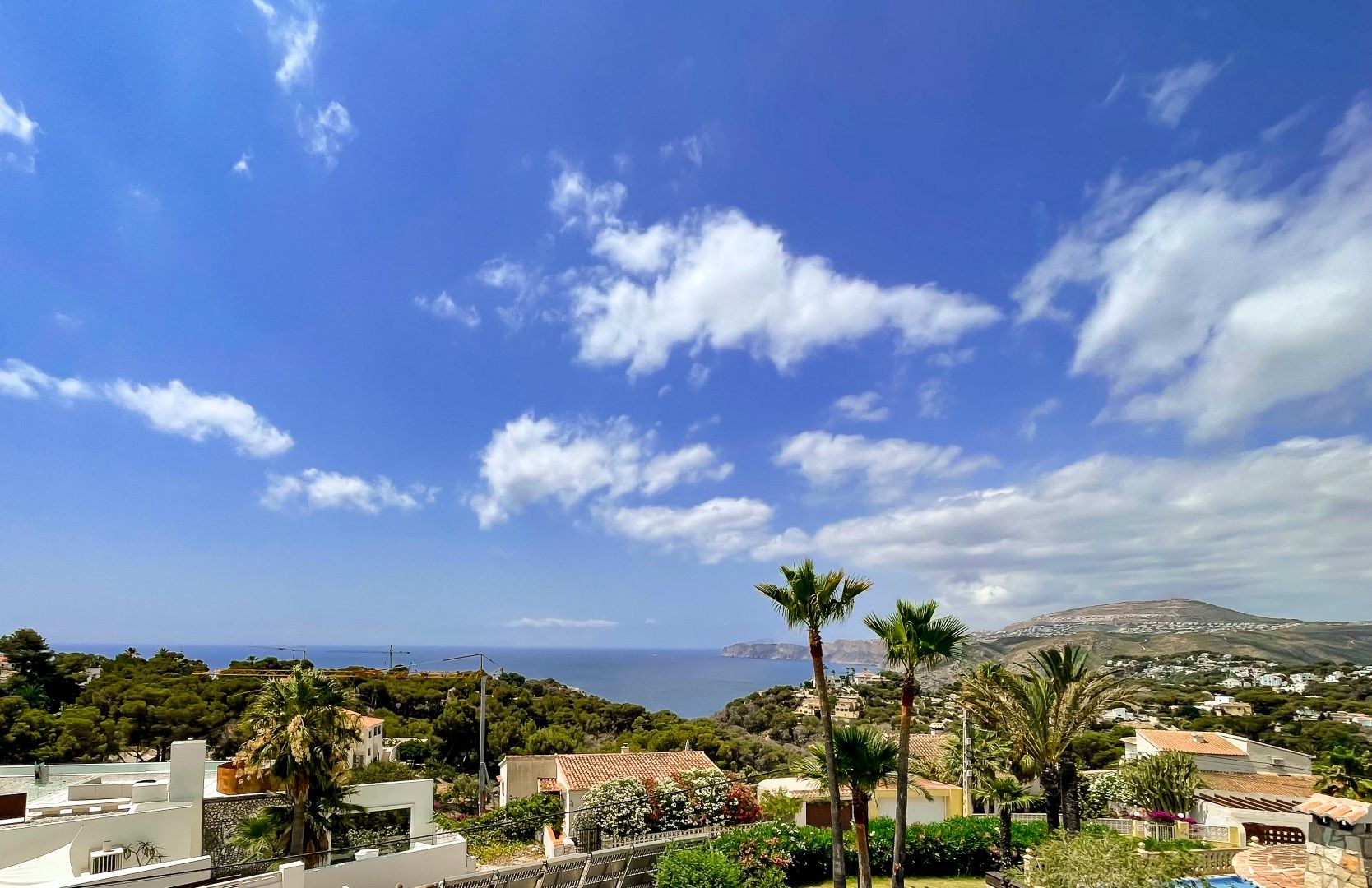 Ononderbroken panoramisch uitzicht op de Middellandse Zee en de groene omgeving van Balcón al Mar, met inheemse vegetatie en de kustlijn van Jávea.