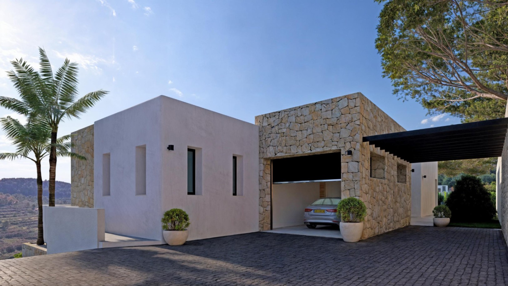 Moderne buitenkant met garage bekleed met steen en grijze oprit.