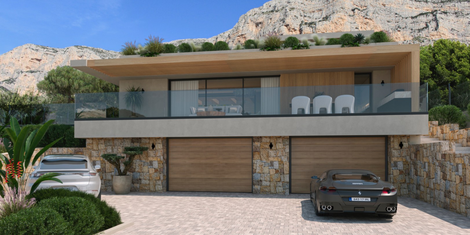Moderne gevel met dubbele garage in natuursteen, ruim boventerras met glazen balustrades en uitzicht op het Montgó-massief.