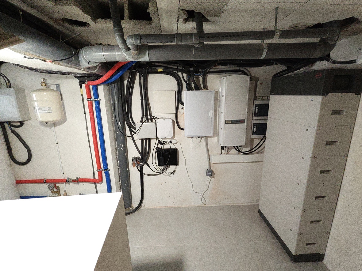 Technische ruimte met SolarEdge-omvormer, BYD-batterijopslagsysteem en georganiseerde loodgietersinstallatie met expansievat en PEX-leidingen.