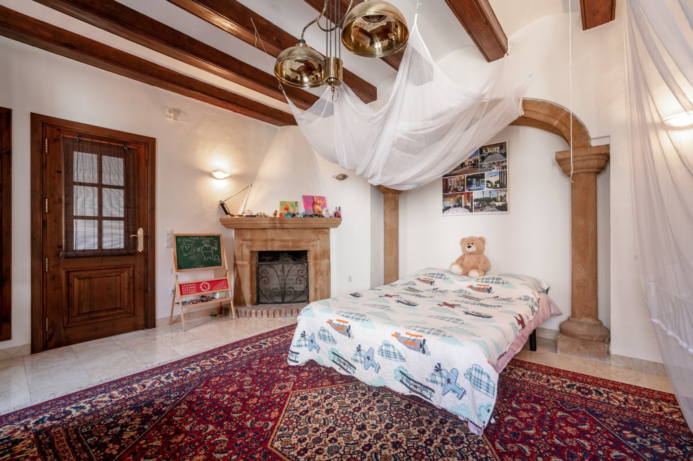 Slaapkamer met houten balkenplafond, Tosca natuurstenen open haard en een architectonische boog, voorzien van marmeren vloeren en een klassiek tapijt.