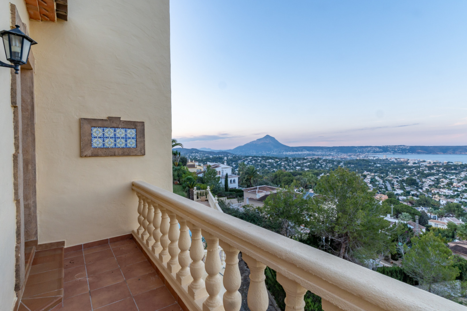 Terras met terracotta vloer en balustrade, met weids uitzicht over de baai van Jávea en het Montgó-gebergte aan de horizon.