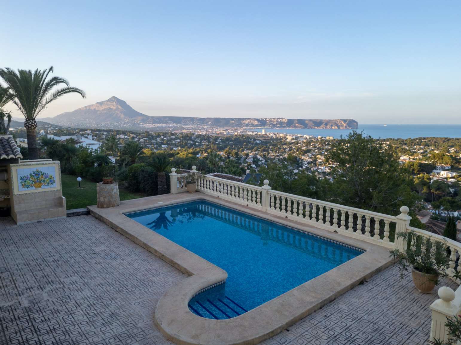 Zwembad met Romeinse trap en stenen balustrade, met panoramisch uitzicht over de baai van Jávea, de Middellandse Zee en de berg Montgó.