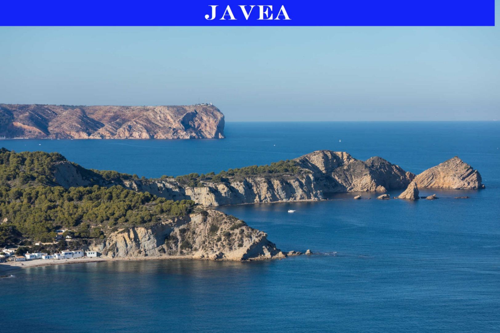 Panoramisch uitzicht op de kustlijn van Javea, met de ruige mediterrane kliffen, helderblauw water en groene pijnboombossen onder een strakke lucht.