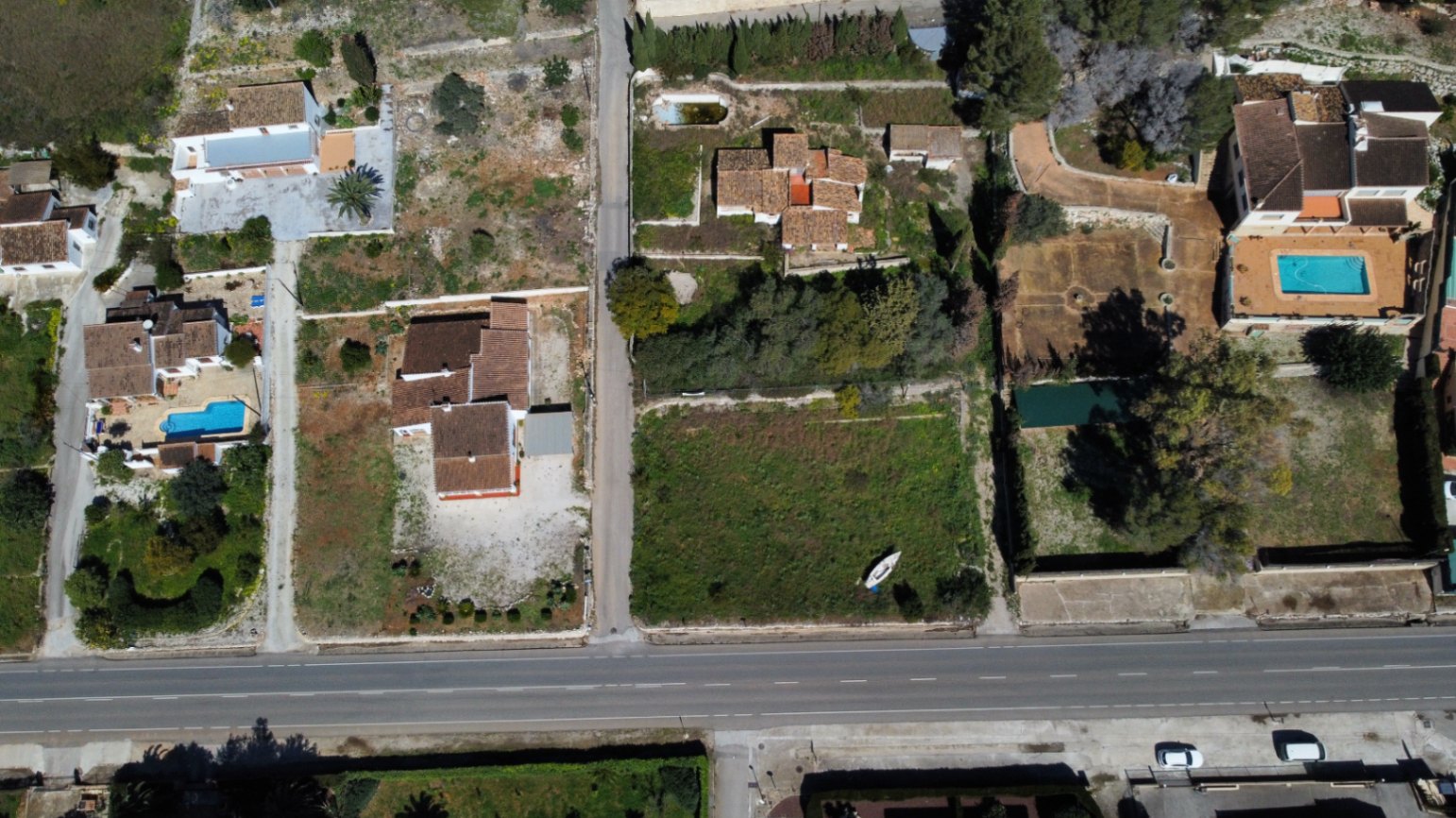 Luchtopname van het perceel van 2.895 m2 in Jávea, met de bestaande woning, de ruime uitbreidingsmogelijkheden en de toegang vanaf de hoofdweg.