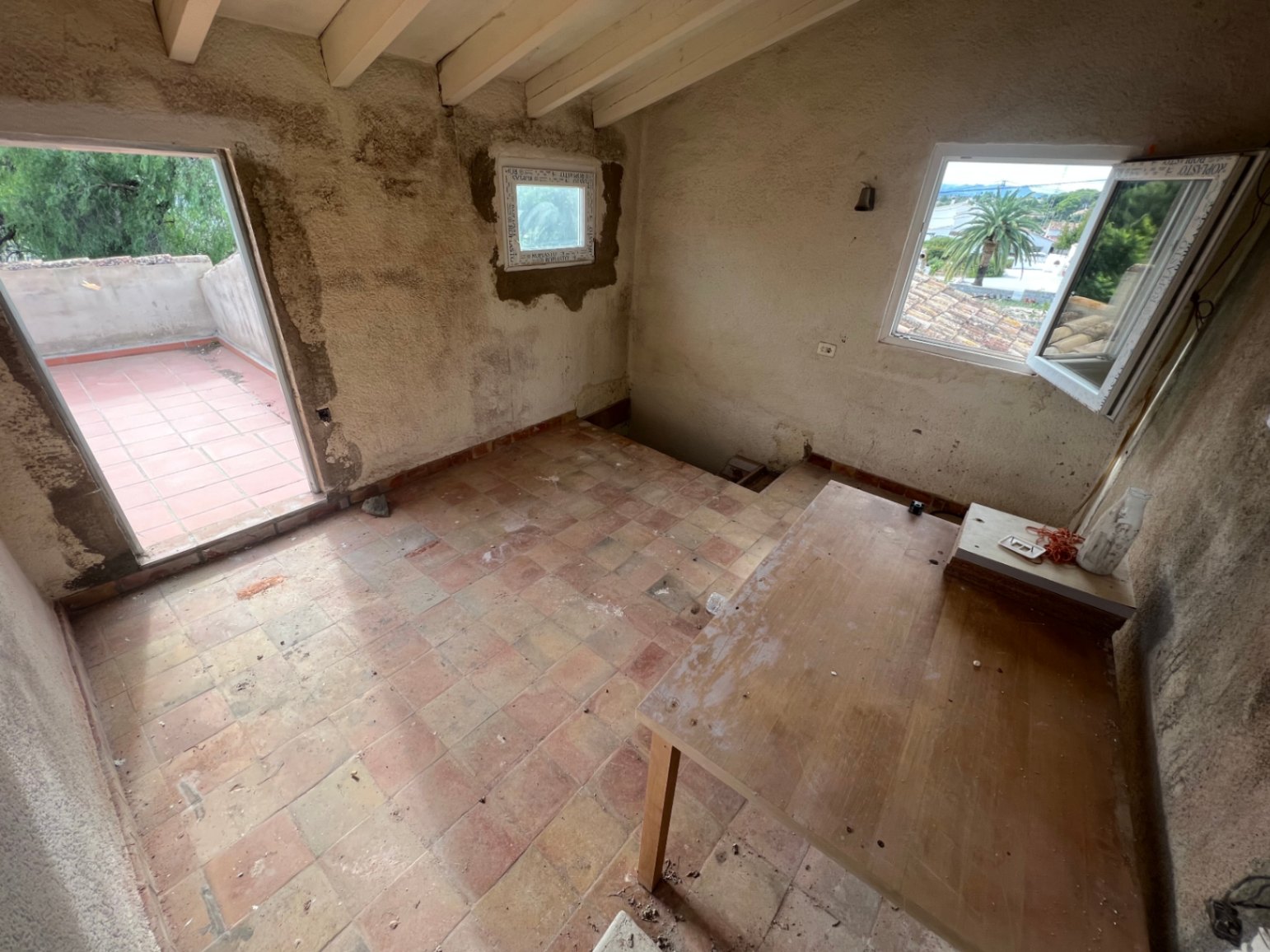 Te renoveren kamer op de bovenverdieping met houten balkenplafond, terracotta vloer en toegang tot een privéterras met uitzicht.
