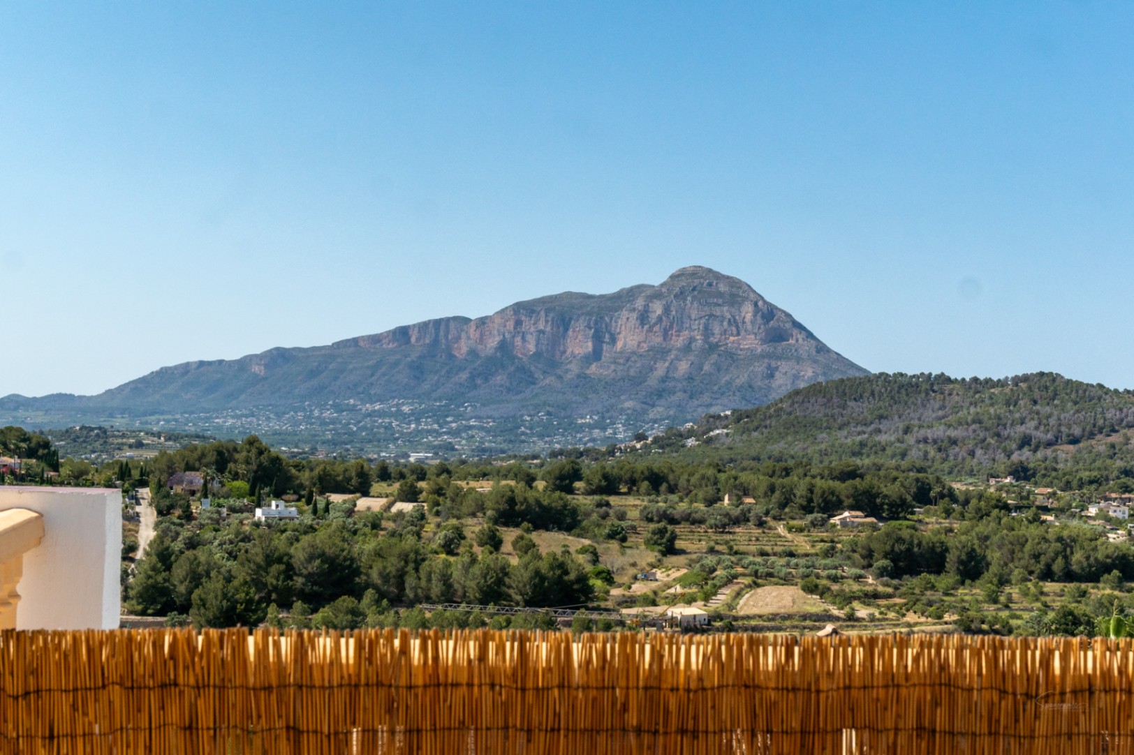 Panoramisch uitzicht op het Montgó-massief vanaf het terras, uitkijkend over een vallei met pijnbomen en mediterrane vegetatie.