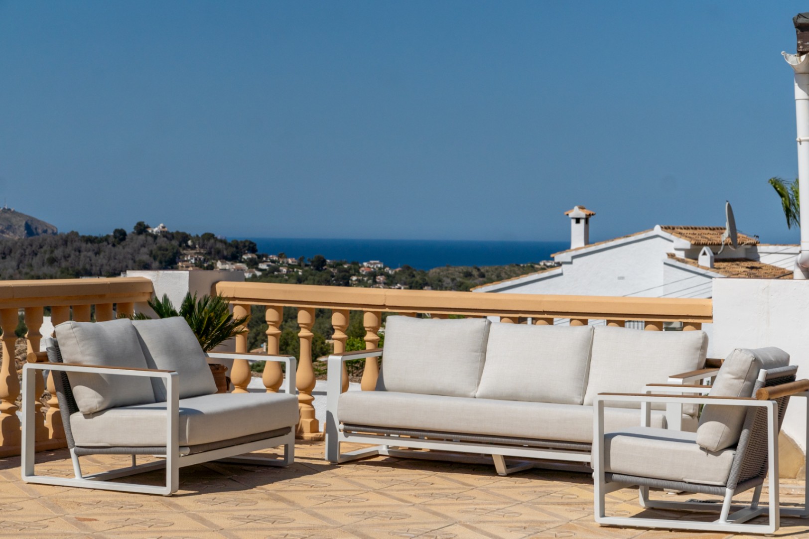 Verhoogd terras met modern tuinmeubilair en panoramisch uitzicht over de Middellandse Zee en de kustlijn van Jávea.