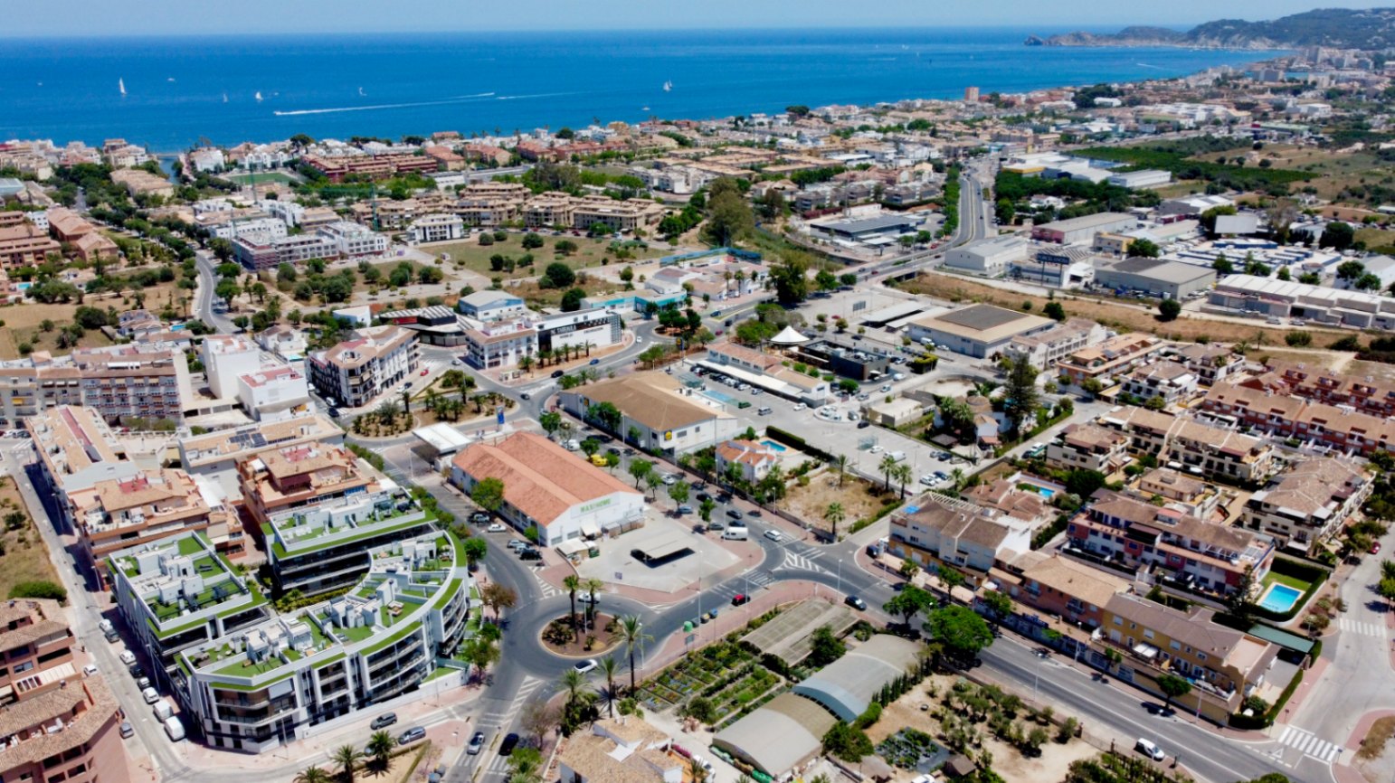 Luchtfoto van Jávea die de nabijheid van het moderne wooncomplex bij de Middellandse Zee en essentiële stedelijke voorzieningen laat zien.