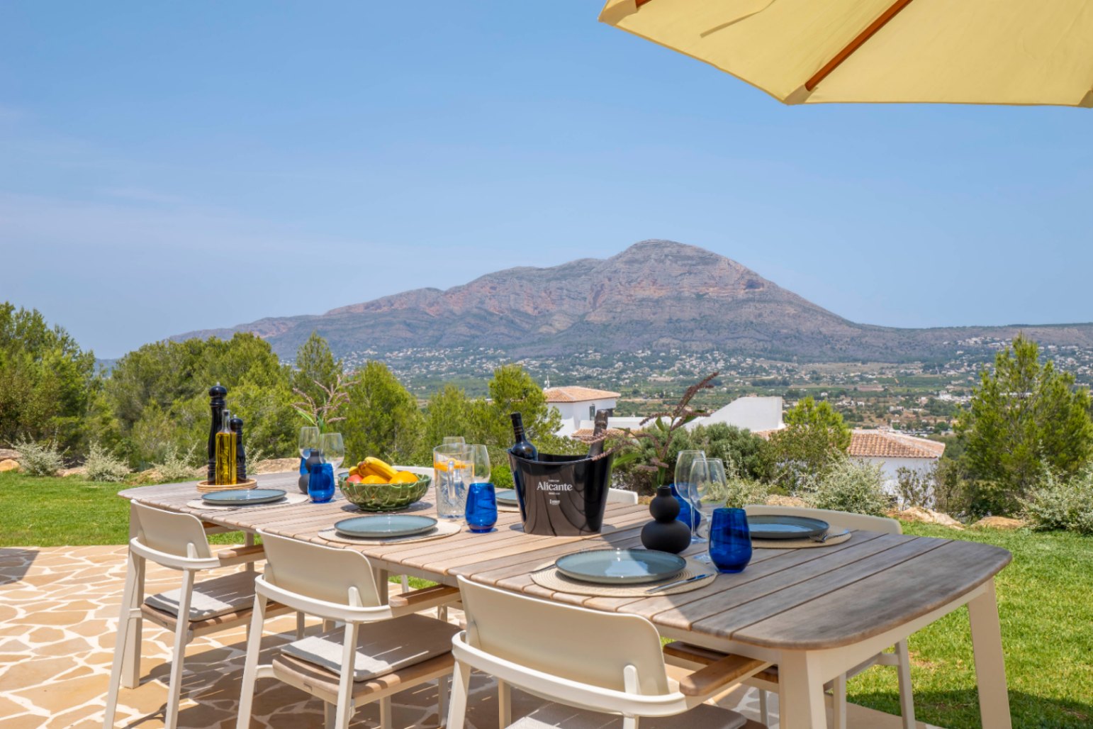 Eetgedeelte buiten met houten tafel en uitzicht op de bergen in Jávea.
