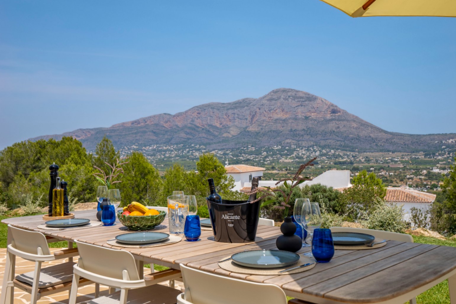Eethoek buiten met houten tafel en uitzicht op de bergen in Jávea.