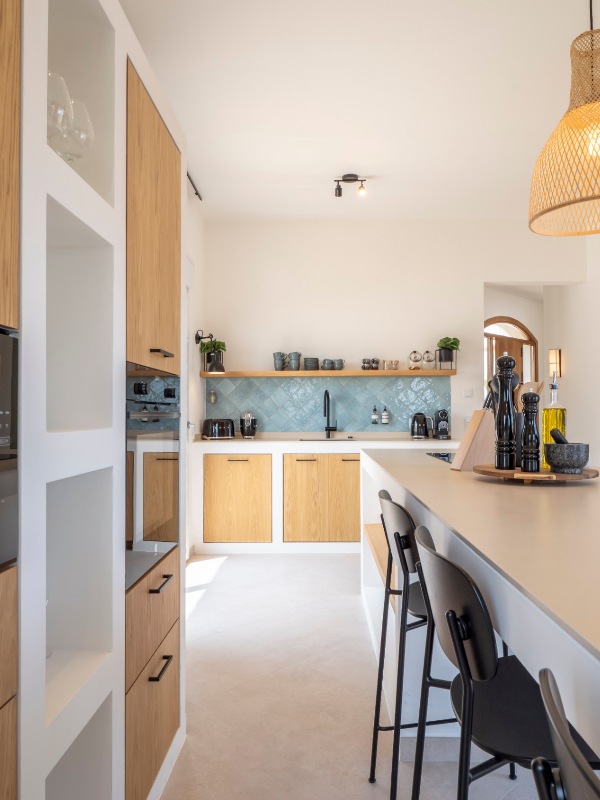 Lichte keuken met kookeiland, lichte houten kasten en turquoise tegelachterwand. Modern en functioneel ontwerp.