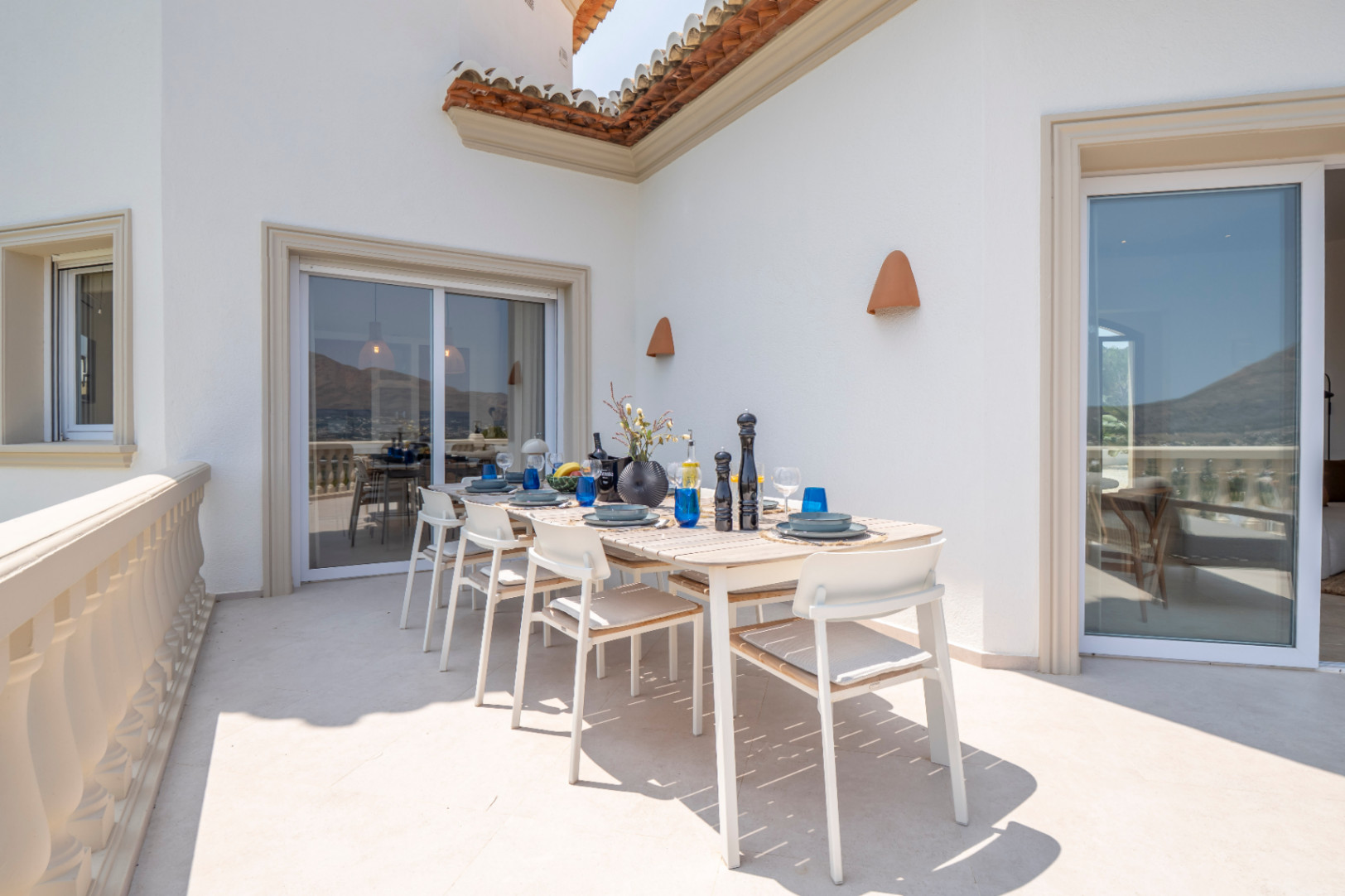 Terras met buiteneethoek, lichte houten tafel en panoramisch uitzicht in Jávea.