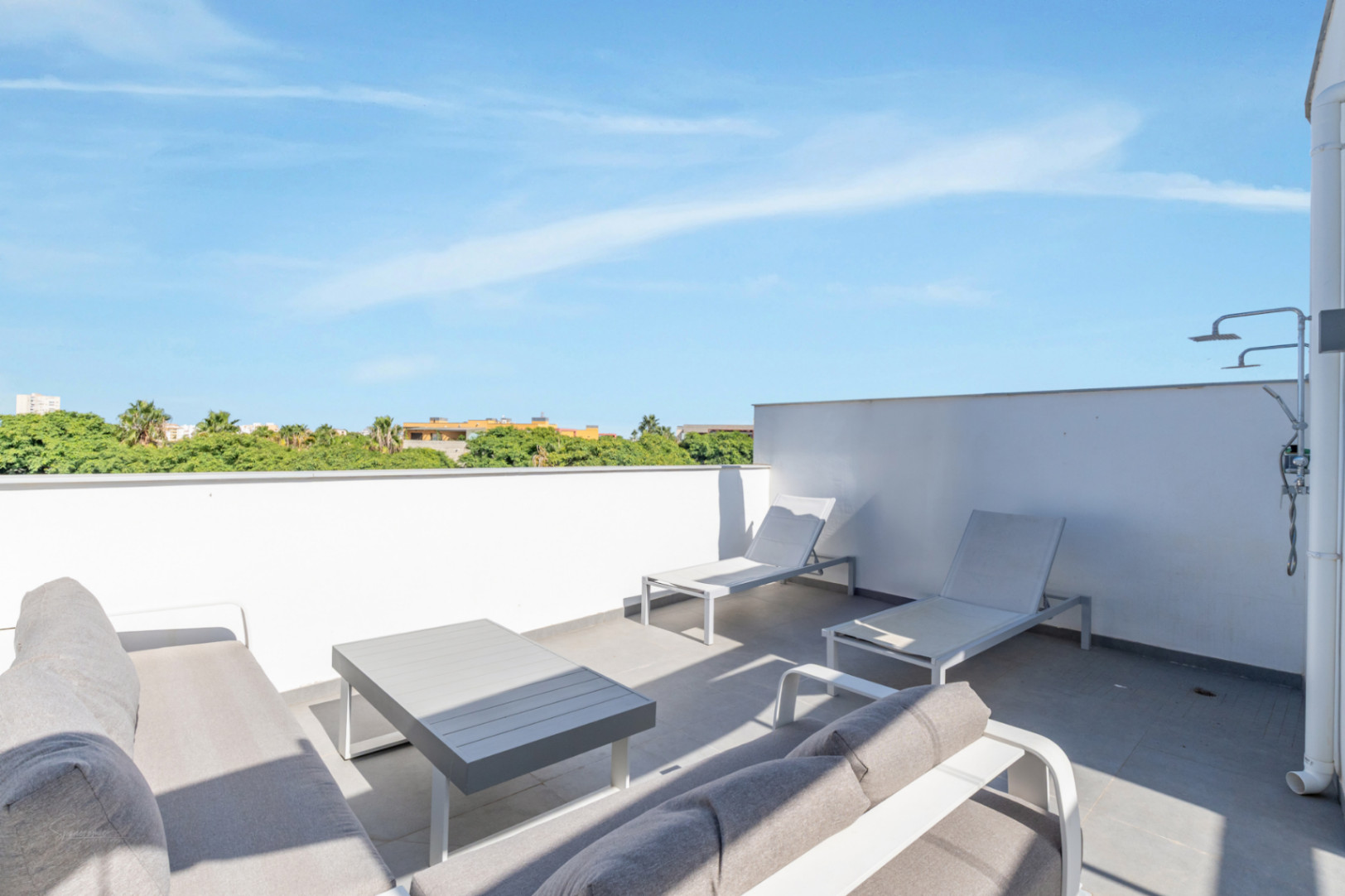 Privé dakterras voorzien van een moderne zithoek, ligbedden en een buitendouche. De ruimte biedt een vrij uitzicht over de omliggende natuur.