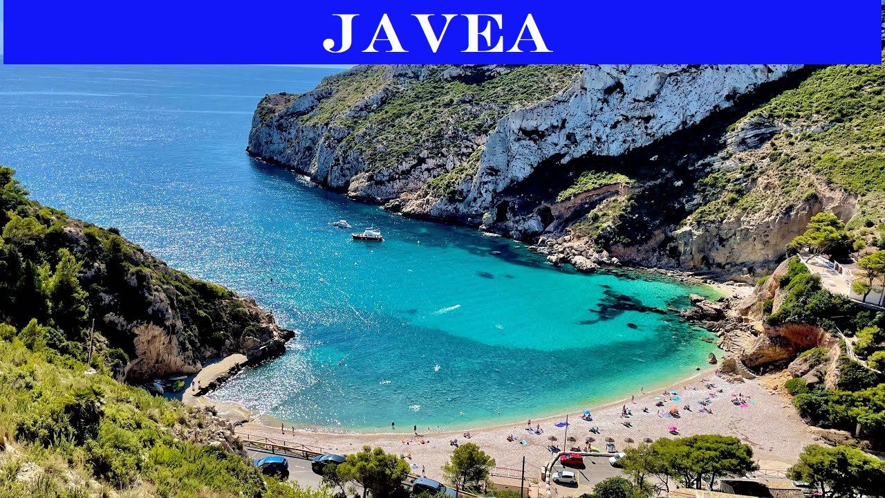 Panoramisch uitzicht op Cala Granadella in Jávea, met kristalhelder turquoise water omgeven door steile kliffen en weelderige mediterrane vegetatie.