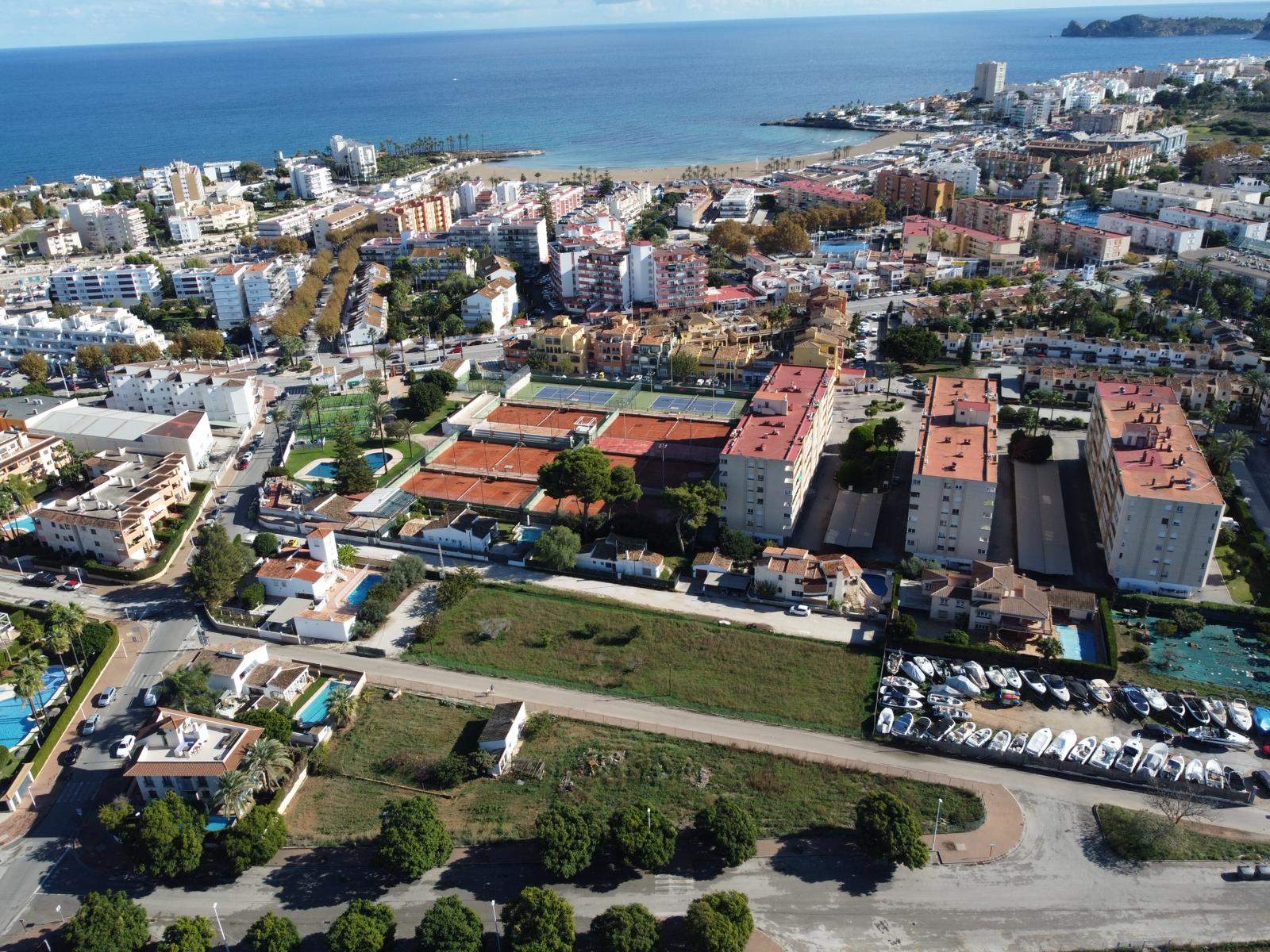 Luchtopname van het bouwperceel in Jávea, met de strategische ligging naast de tennisclub en op korte afstand van het Arenal-strand en de Middellandse Zee.