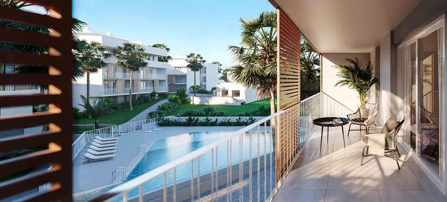 Privéterras met tegelvloer en modern meubilair, met uitzicht op het gemeenschappelijke zwembad en de aangelegde mediterrane tuinen.