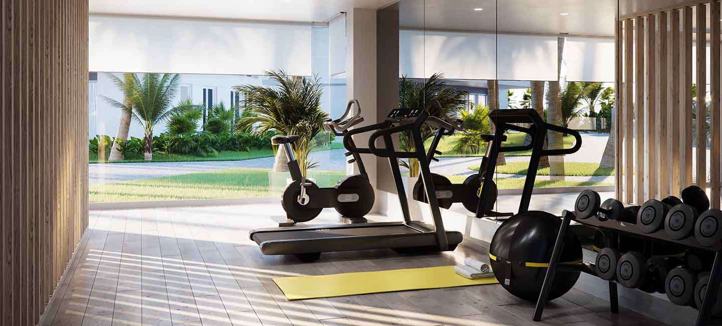 Moderne fitnessruimte met cardio-apparatuur, gewichten en kamerhoge ramen met uitzicht op de mediterrane tuinen en palmbomen.
