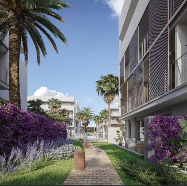 Een geplaveid pad slingert door de gemeenschappelijke tuinen met paarse bougainville, palmbomen en moderne gevels voorzien van verticale zonwering.