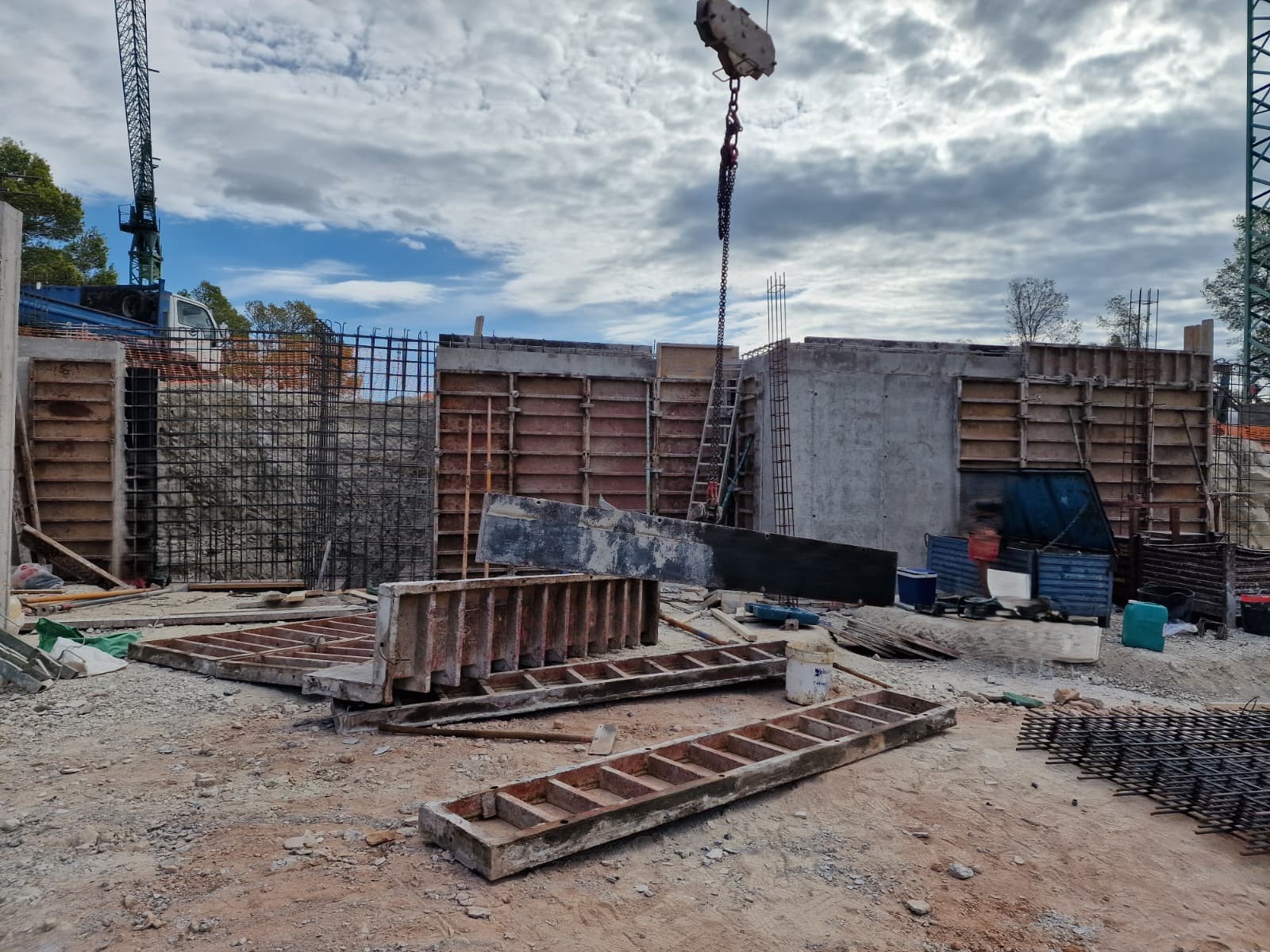 Voortgang van de ruwbouwfase met gewapende betonmuren, metalen bekistingen en kraanwerkzaamheden op de bouwplaats in Moraira.