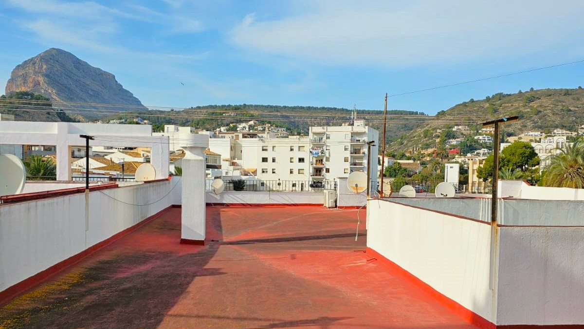Gemeenschappelijk dakterras met rode vloer en weids uitzicht op de Montgó-berg en de omliggende heuvels van de oude binnenstad van Javea.