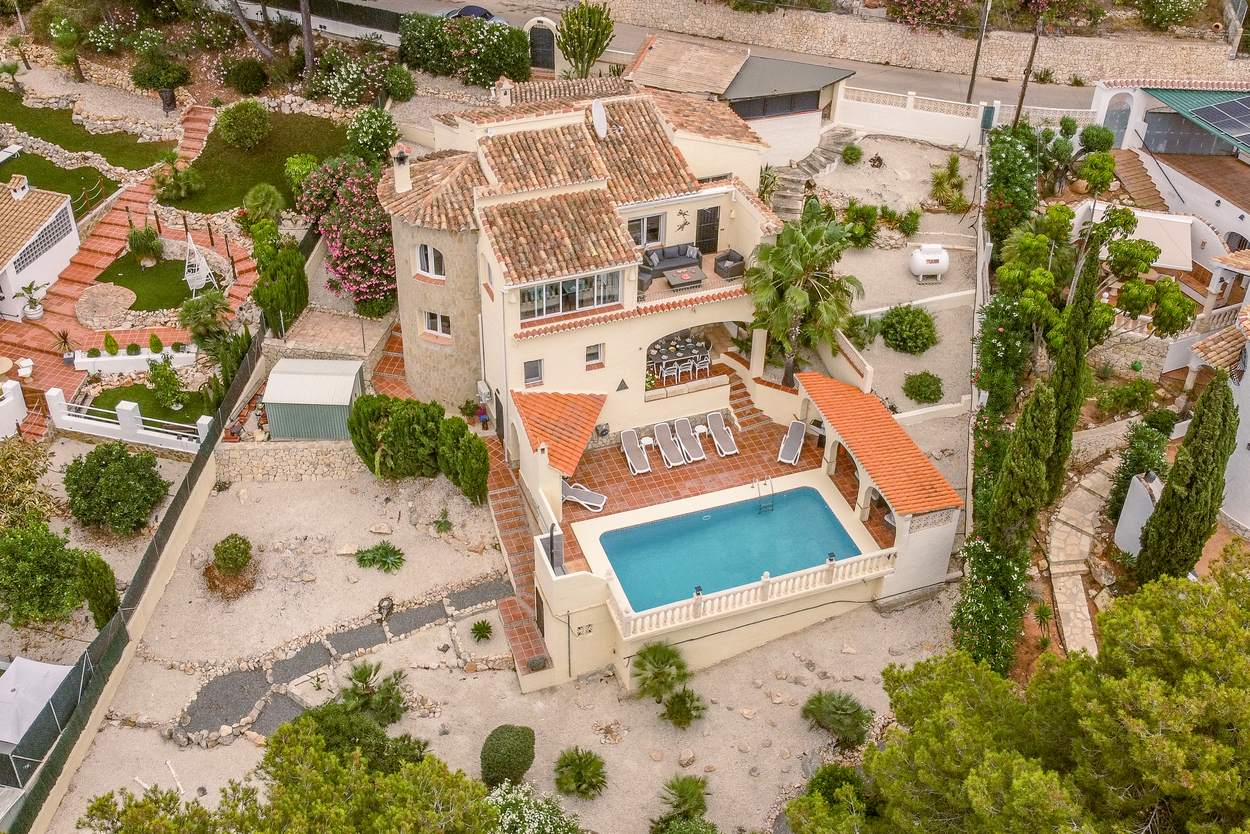 Luchtfoto van de villa met 8x4m zwembad, terracotta terrassen en een stenen toren, omgeven door een onderhoudsvriendelijke mediterrane tuin.