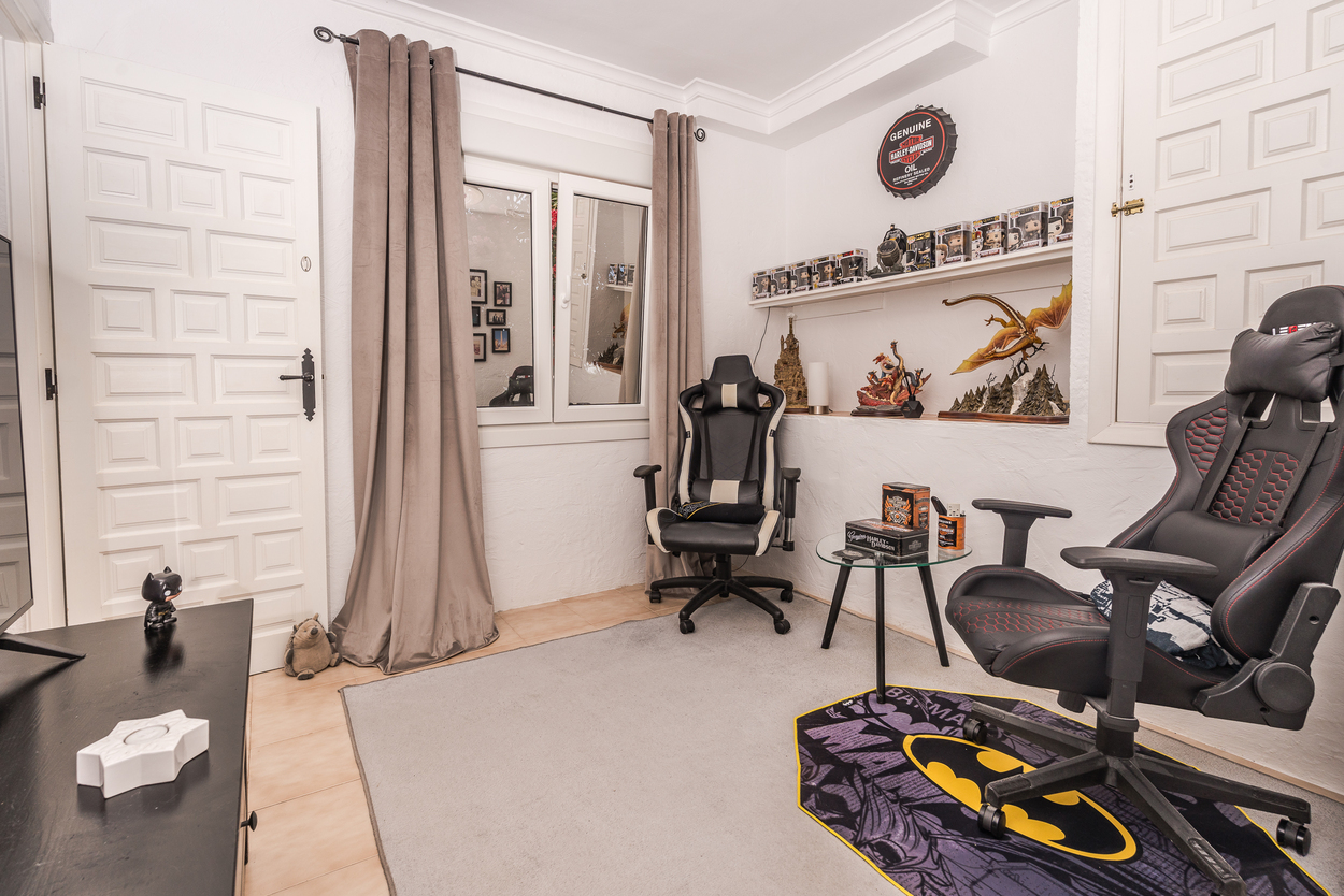 Moderne hobbykamer met ergonomische gamestoelen, witte paneeldeuren en ingebouwde schappen. Voorzien van dubbele beglazing en een lichte tegelvloer.