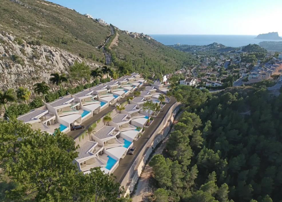 Luchtfoto van zestien moderne terrasvilla's in Benitachell, elk met een privézwembad en panoramisch uitzicht op de Middellandse Zeekust en de Peñón de Ifach.