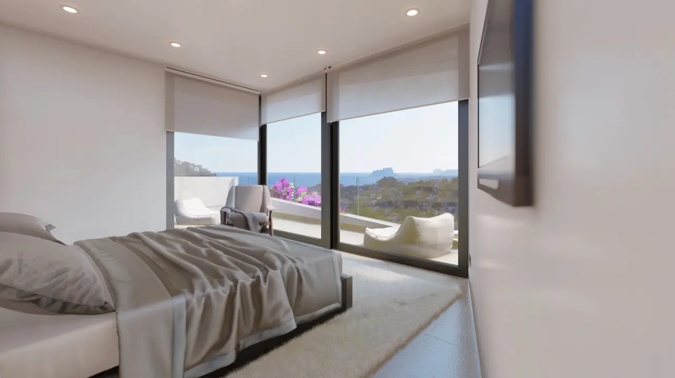 Moderne slaapkamer met kamerhoge ramen, panoramisch uitzicht op de Middellandse Zee en de Peñón de Ifach, en toegang tot een privéterras.