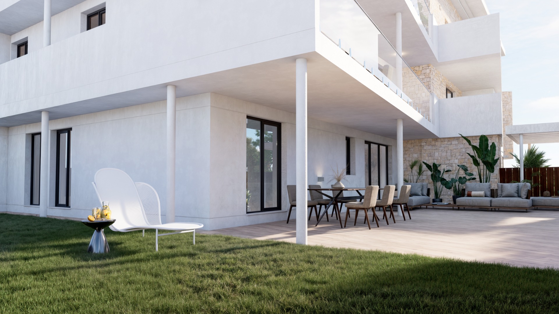 Begane grond terras met houtlook vloer, eigen gazon en modern buitenmeubilair. De witte gevel is afgewerkt met natuurstenen muren en glazen balustrades op de verdiepingen.
