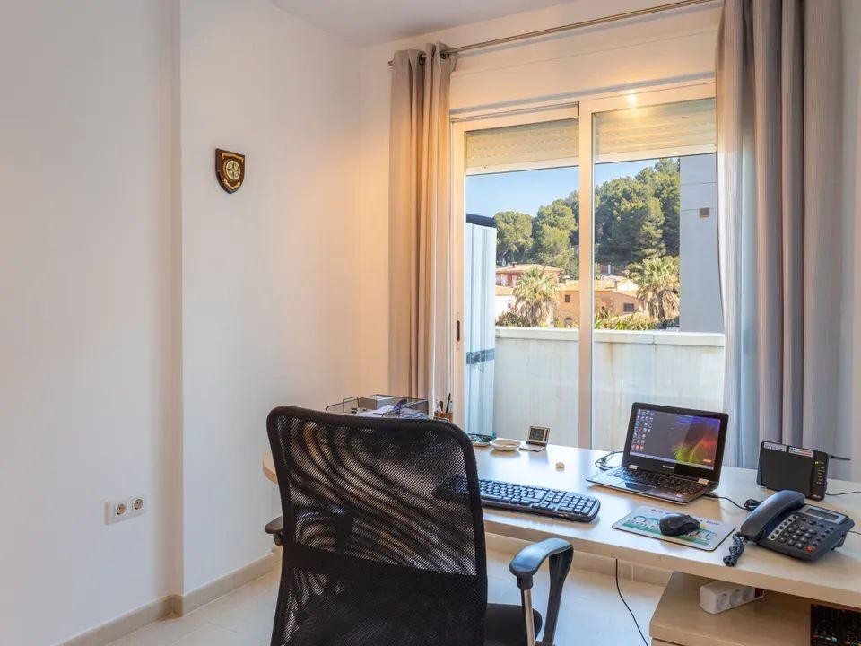 Lichte werkkamer met ruim bureau en schuifpui die direct uitzicht biedt op de groene heuvels en de omliggende natuur van Jesús Pobre.