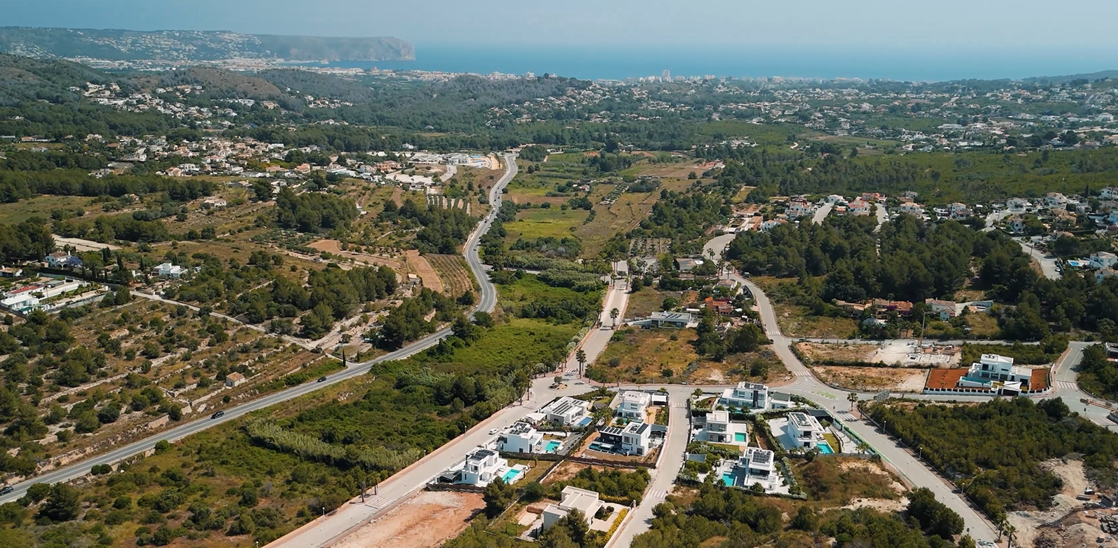 Luchtfoto van de woonwijk Villas del Vent in Jávea, met moderne villa's en percelen met panoramisch uitzicht op de Middellandse Zee en de kustlijn.