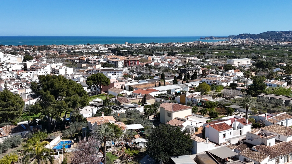 Panoramisch uitzicht vanaf het terras over de daken van Javea Pueblo, uitkijkend op de Middellandse Zee en de verre kustlijn bij helder weer.