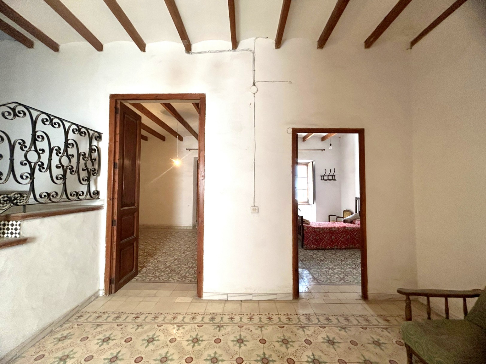 Hal met originele hydraulische tegelvloeren en houten balkenplafonds. Deze ruimte verbindt kamers die zijn voorzien van authentiek houtwerk en historisch karakter.
