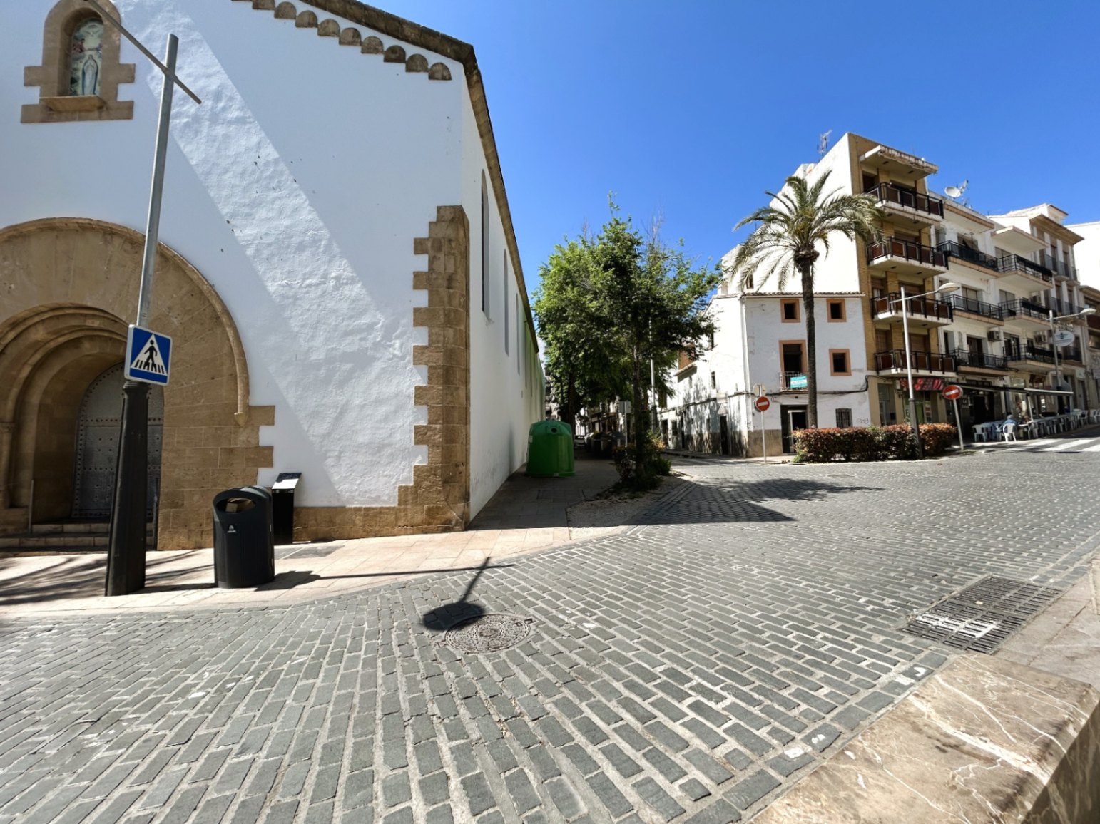 Buitenaanzicht van de geplaveide straat naast een historisch gebouw met traditionele Tosca-stenen bogen in het oude centrum van Jávea.