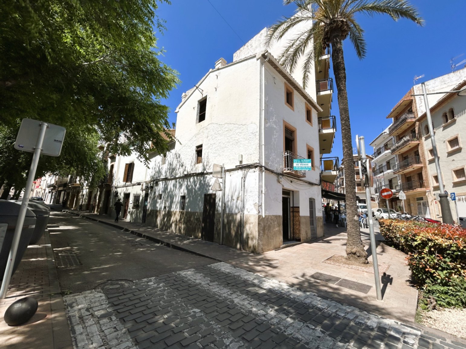 Hoekgevel van het herenhuis met drie verdiepingen in het oude centrum van Jávea, voorzien van authentieke houten luiken en een witgepleisterde afwerking.