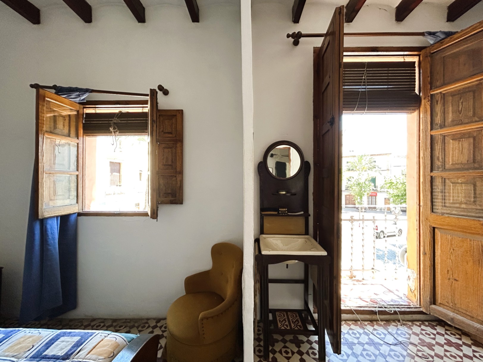 Traditionele kamer met houten balkenplafond, originele hydraulische tegelvloer en balkon met uitzicht op het oude centrum van Jávea. Inclusief een vintage wastafel.