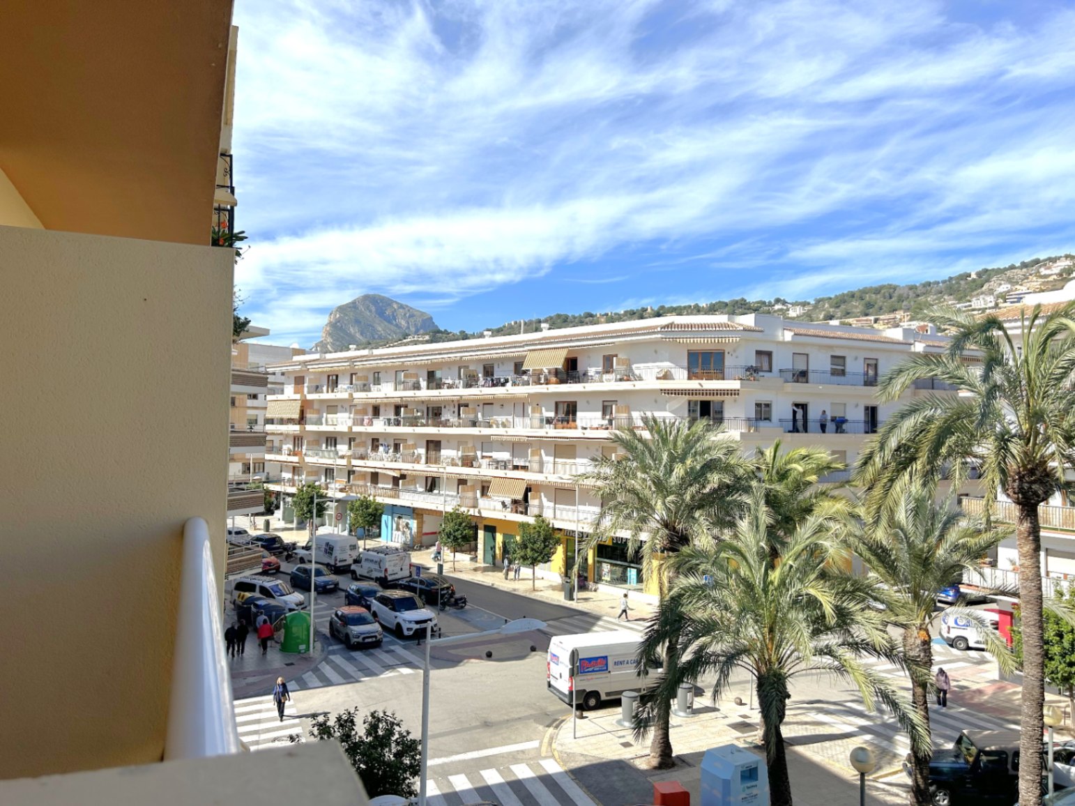 Vrij uitzicht vanaf het balkon over het centrum van Puerto de Jávea, met de iconische berg Montgó op de achtergrond en straten omzoomd met mediterrane palmbomen.