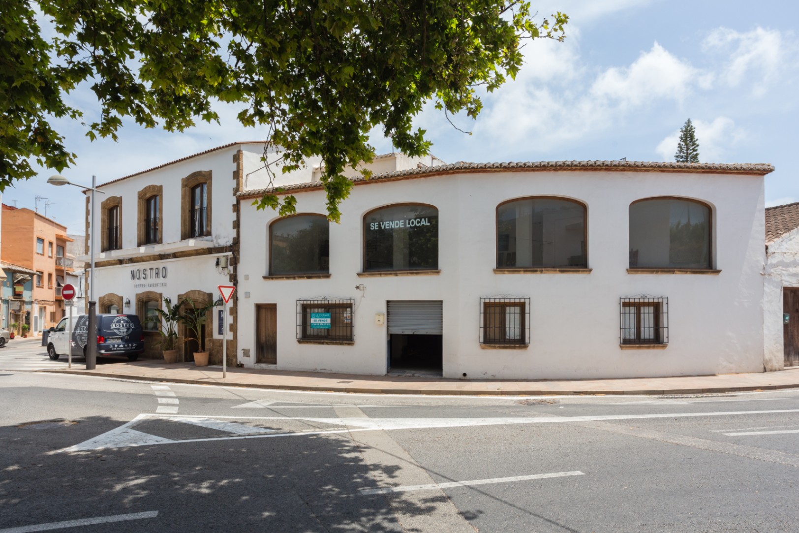 Buitengevel op een hoeklocatie in Jávea met traditionele tosca stenen omlijstingen, grote ramen op de bovenverdieping en een mediterrane structuur.