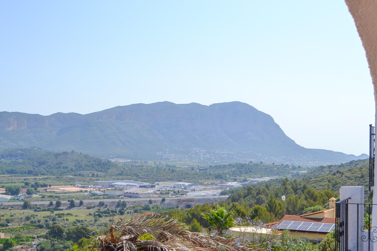 Weids panoramisch uitzicht over de vallei en het Montgó-gebergte vanaf het verhoogde terras, omgeven door een mediterraan landschap.