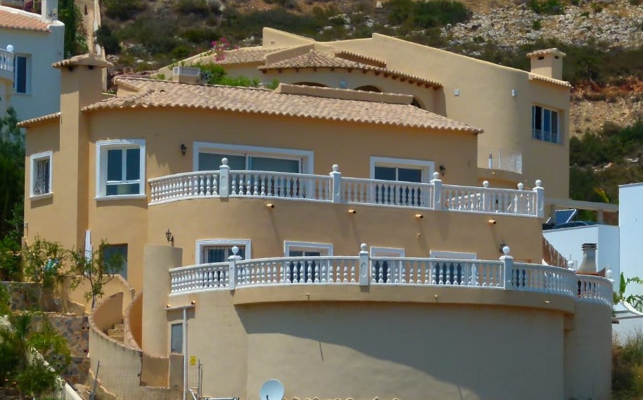 Exterieur van villa met gebogen balkons en witte balustrades in Cumbre del Sol.