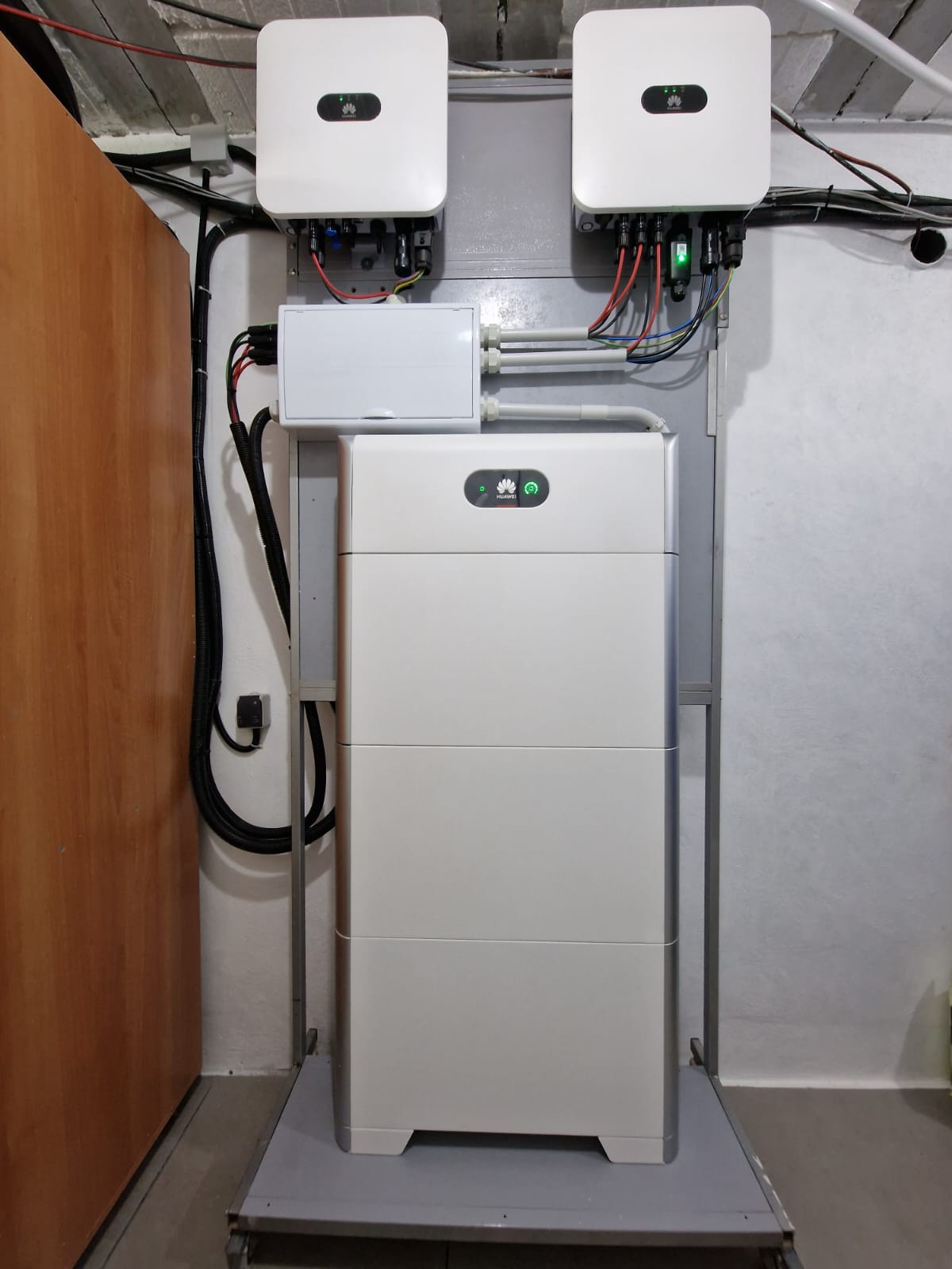 Huawei zonneregelaars en batterij-installatie in een technische ruimte. Zichtbare bedrading.
