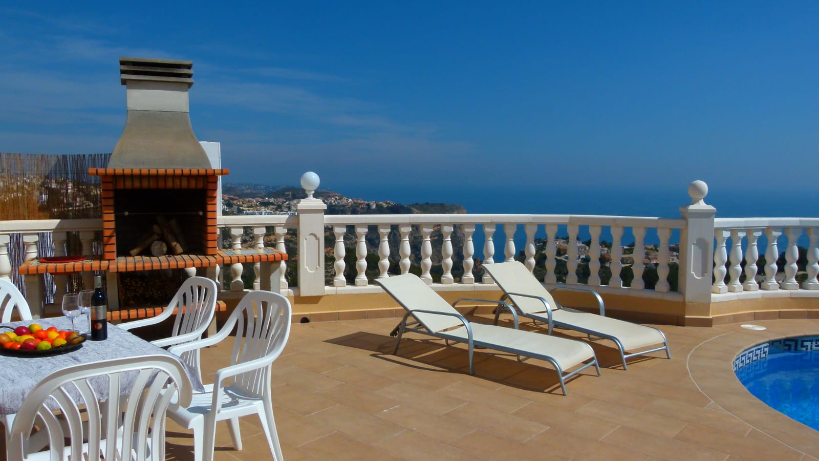 Terras met bakstenen BBQ, ligstoelen en uitzicht op zee vanaf Cumbre del Sol, Benitachell.